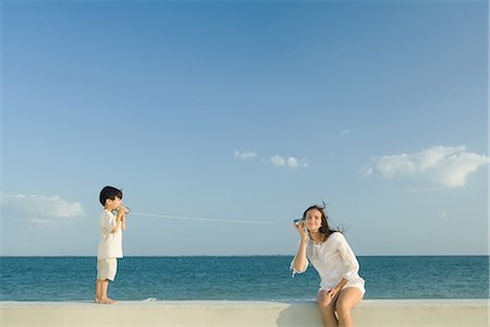 Boy and young woman using tin can phones Foto de stock - Sin royalties Premium, Código: 695-05767456