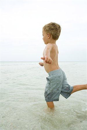 simsearch:695-03377206,k - Little boy standing in shallow water, posed to kick Foto de stock - Sin royalties Premium, Código: 695-05767475