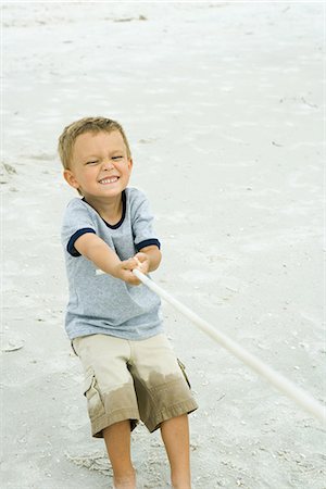 Little boy pulling on rope, making face, on beach Stock Photo - Premium Royalty-Free, Code: 695-05767473