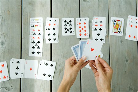 playing card images on hand - Woman playing solitaire, cropped view of hands and cards Stock Photo - Premium Royalty-Free, Code: 695-05767514
