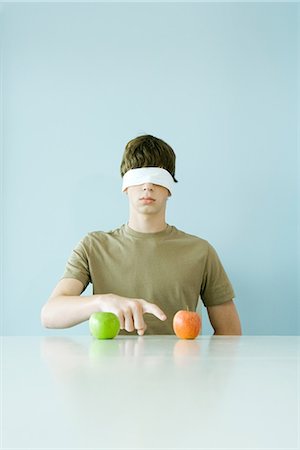 people with fruits cutout - Young male wearing blindfold, pointing to one of two apples Stock Photo - Premium Royalty-Free, Code: 695-05767544