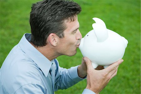 side view of pig - Man kissing piggy bank, side view Stock Photo - Premium Royalty-Free, Code: 695-05767542