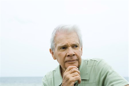 depressed body language - Senior man with hand under chin, furrowing brow, looking away Stock Photo - Premium Royalty-Free, Code: 695-05767628