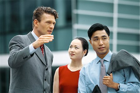 Business associates standing outdoors, talking, man gesturing with hand Stock Photo - Premium Royalty-Free, Code: 695-05767733