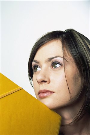 simsearch:695-03377755,k - Female leaning chin against folder, looking up, close-up Stock Photo - Premium Royalty-Free, Code: 695-05767742