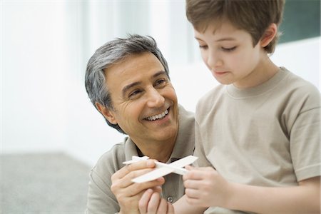 father and son with toy airplane - Mature man and boy holding toy plane Stock Photo - Premium Royalty-Free, Code: 695-05767924