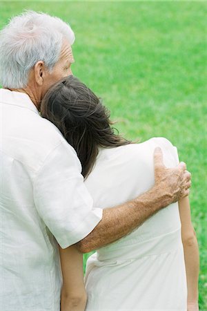 Teen girl leaning head on grandfather's shoulder, rear view Stock Photo - Premium Royalty-Free, Code: 695-05767994
