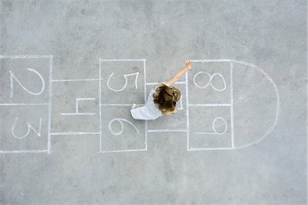 Little girl playing hopscotch, overhead view Stock Photo - Premium Royalty-Free, Code: 695-05768021