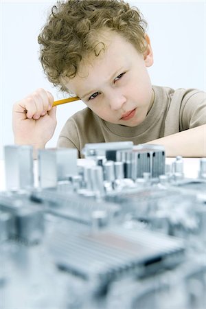 Little boy with circuit board, holding pencil, looking at camera Stock Photo - Premium Royalty-Free, Code: 695-05768023