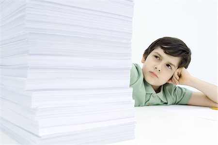 scale and frustrated - Boy looking at tall stack of homework, frowning Stock Photo - Premium Royalty-Free, Code: 695-05768032