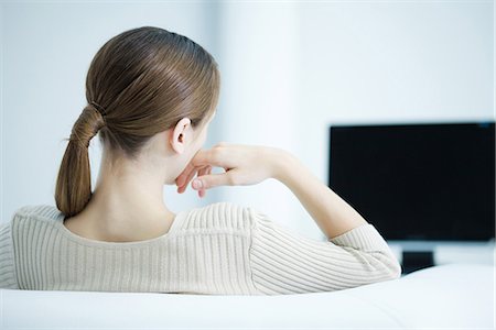 Young woman watching TV, rear view Stock Photo - Premium Royalty-Free, Code: 695-05768042