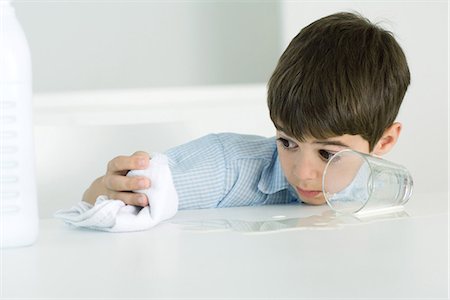 Little boy wiping up spilled milk with towel Stock Photo - Premium Royalty-Free, Code: 695-05768087