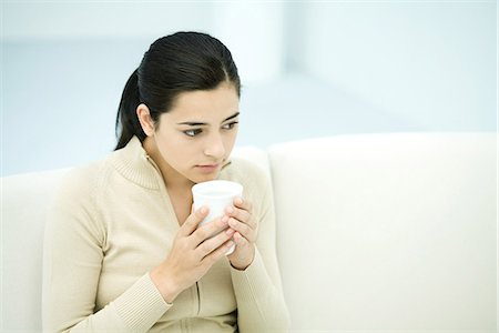 Junge Frau sitzend, halten Kaffeetasse, Wegsehen Stockbilder - Premium RF Lizenzfrei, Bildnummer: 695-05768095