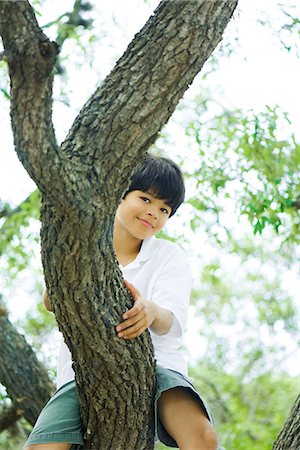 people sitting on branch tree - Boy sitting in tree, smiling at camera Stock Photo - Premium Royalty-Free, Code: 695-05768134