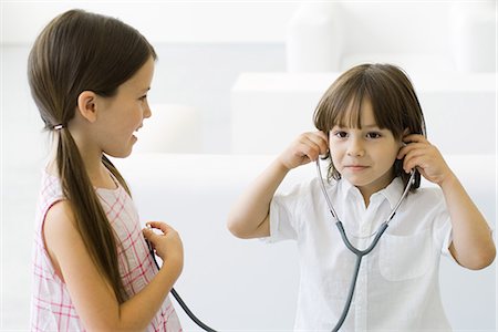Petit garçon écoute au cœur de la jeune fille avec stéthoscope Photographie de stock - Premium Libres de Droits, Code: 695-05768235