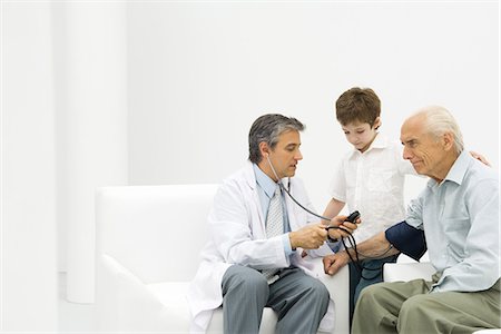 doctor measuring boy - Doctor measuring elderly man's blood pressure, boy watching Stock Photo - Premium Royalty-Free, Code: 695-05768241