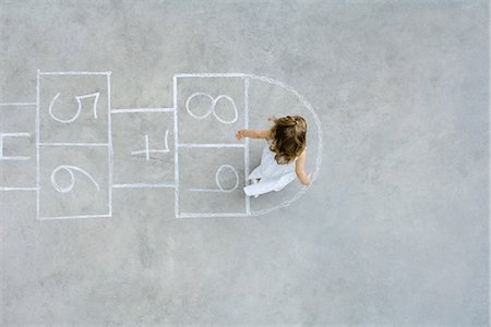 people skipping - Girl playing hopscotch, overhead view Stock Photo - Premium Royalty-Free, Code: 695-05768252