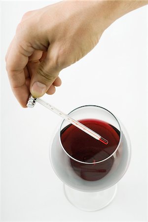 Person holding thermometer over glass of red wine, cropped view of hand Stock Photo - Premium Royalty-Free, Code: 695-05768272