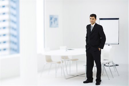 executive, chair - Businessman standing in meeting room, hands in pockets Stock Photo - Premium Royalty-Free, Code: 695-05768295