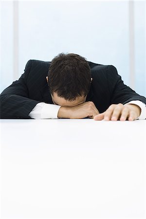 Businessman with head down, arm over eyes Stock Photo - Premium Royalty-Free, Code: 695-05768302