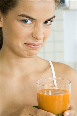 reject food - Woman holding glass of vegetable juice, frowning at camera Stock Photo - Premium Royalty-Free, Code: 695-05768333