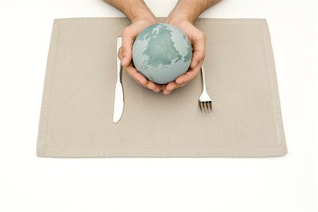 placemat - Hands holding globe over placemat and silverware Stock Photo - Premium Royalty-Free, Code: 695-05768404