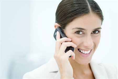 simsearch:695-03380514,k - Young woman talking on cell phone, smiling at camera, portrait Fotografie stock - Premium Royalty-Free, Codice: 695-05768465