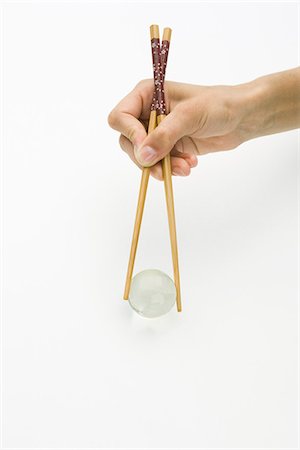 simsearch:695-05768469,k - Hands using chopsticks to hold transparent globe, cropped view Stock Photo - Premium Royalty-Free, Code: 695-05768473