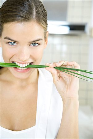 Woman biting into chives, smiling Stock Photo - Premium Royalty-Free, Code: 695-05768503
