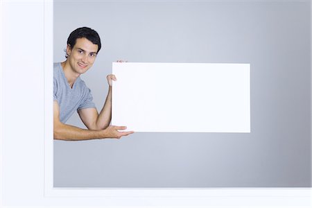 people holding a poster - Man holding blank sign, smiling at camera Stock Photo - Premium Royalty-Free, Code: 695-05768532