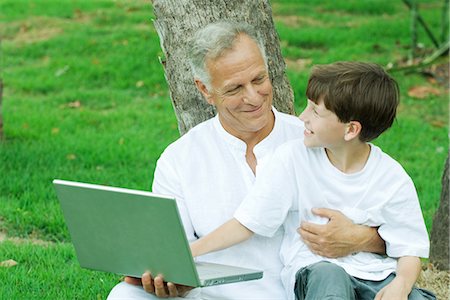 Boy sitting on grandfather's lap, using laptop computer Stock Photo - Premium Royalty-Free, Code: 695-05768570