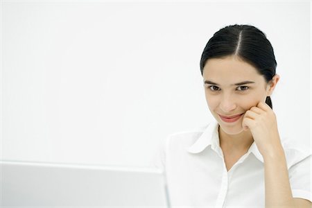 person and lap top and cut out - Young woman leaning on elbow, smiling at camera Stock Photo - Premium Royalty-Free, Code: 695-05768641