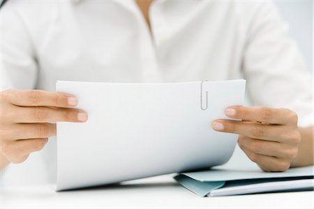 Woman hold document bound with paperclip, cropped view Stock Photo - Premium Royalty-Free, Code: 695-05768658