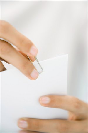 Hands putting paperclip on document, close-up Stock Photo - Premium Royalty-Free, Code: 695-05768659