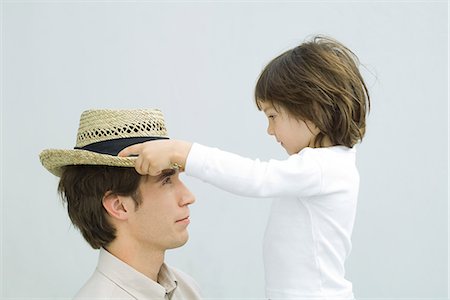 simsearch:695-03389917,k - Little boy putting straw hat on his father's head, side view Foto de stock - Royalty Free Premium, Número: 695-05768688