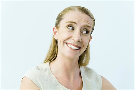 skeptic - Woman smiling, raising eyebrows, looking away Stock Photo - Premium Royalty-Free, Code: 695-05768740