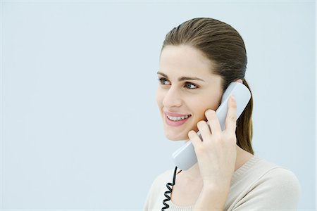 simsearch:695-05770356,k - Woman talking on landline phone, looking away and smiling Stock Photo - Premium Royalty-Free, Code: 695-05768809