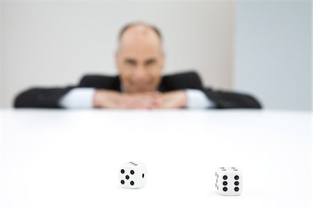 Pair of dice, businessman in background Foto de stock - Royalty Free Premium, Número: 695-05768825