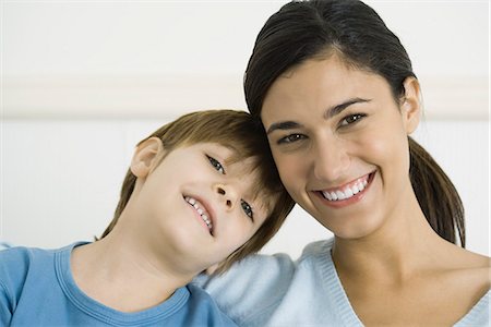 Little boy leaning his head on his mother's shoulder, both smiling, portrait Stock Photo - Premium Royalty-Free, Code: 695-05768879