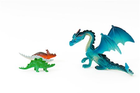 simsearch:695-03380351,k - Dragon jouet face à trois dinosaures petit jouet Photographie de stock - Premium Libres de Droits, Code: 695-05768899