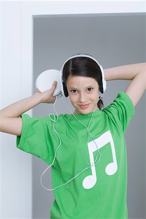 Girl listening to portable CD player, wearing tee-shirt with musical note printed on it Stock Photo - Premium Royalty-Free, Code: 695-05768993