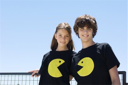 seines und ihres - Junges Paar tragen t-Shirts bedruckt mit grafischen Zeichen, lächelnd in die Kamera Stockbilder - Premium RF Lizenzfrei, Bildnummer: 695-05769000