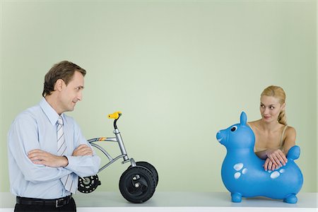 Couple standing by toys, looking at each other, man's arms folded Foto de stock - Sin royalties Premium, Código: 695-05769113