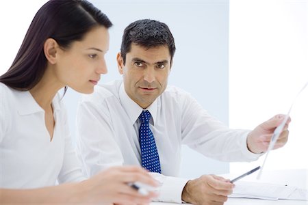 Businessman showing document to female associate Stock Photo - Premium Royalty-Free, Code: 695-05769185