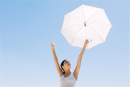 simsearch:632-05991689,k - Woman holding up parasol, eyes closed Fotografie stock - Premium Royalty-Free, Codice: 695-05769276