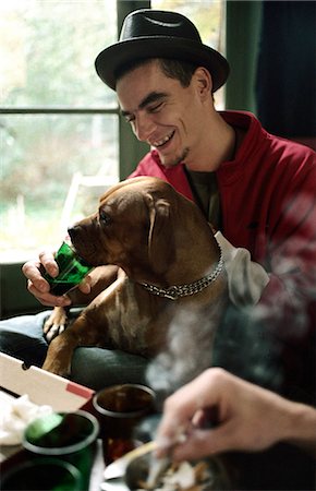 dog sitting on a window - Young man letting pet dog drink from glass Stock Photo - Premium Royalty-Free, Code: 695-05769350