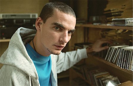 Young man selecting CD from collection on shelf Foto de stock - Sin royalties Premium, Código: 695-05769352