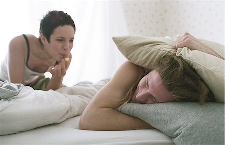 Young woman blowing whistle, awakening sleeping young man Stock Photo - Premium Royalty-Free, Code: 695-05769386