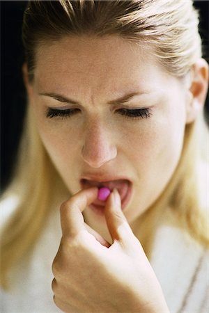 desagradable - Woman placing pill on tongue Foto de stock - Sin royalties Premium, Código: 695-05769636