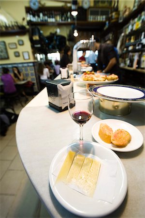 restaurant bar counters - Plate of Manchego cheese, half finished glass of wine in tapas bar Foto de stock - Sin royalties Premium, Código: 695-05769682